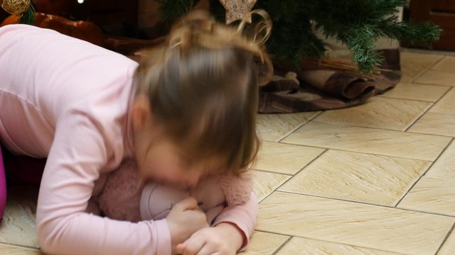 enfant au pied du sapin jouant avec ses cadreaux