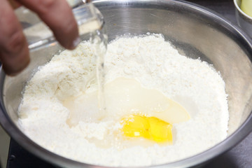 Preparation of the dough. Water add in the sifted flour