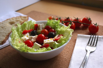 Greek salad with cherry tomatoes, red peppers, black olives,onion and feta cheese. Selective focus. 