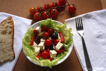 Greek salad with cherry tomatoes, red peppers, black olives,onion and feta cheese. Selective focus.