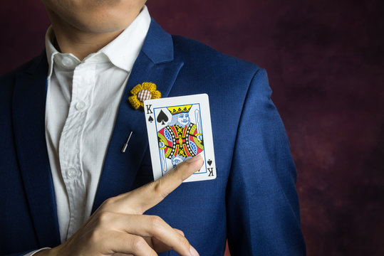 man in blue suit picking king spades
