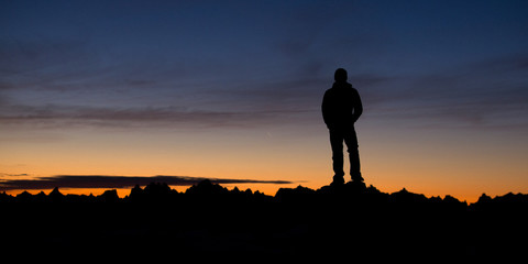 Hiker on top of mountains at sunrise