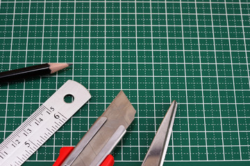 Closeup of ruler,scissors, cutter, cutting mat, pencil