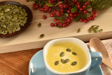 Pumpkin soup in a blue bowl and Heteromeles