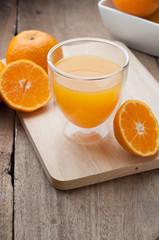 Glass of orange juice on wooden cutting boards.