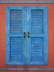 old blue window on red wall