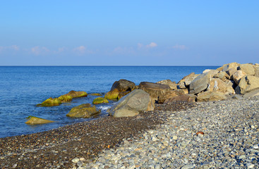 Большие камни-валуны на галечном пляже на берегу Черного моря