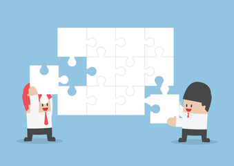 Businessman help each other to assemble blank jigsaw