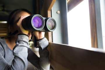 Asian woman use of the binoculars for birdwatching