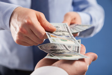 Human hands exchanging money on blue background