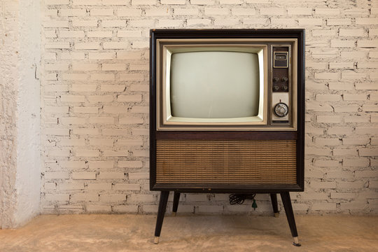 Fototapeta Retro old television in vintage white wall background