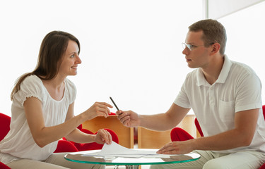 Smiling young business people signing a contract