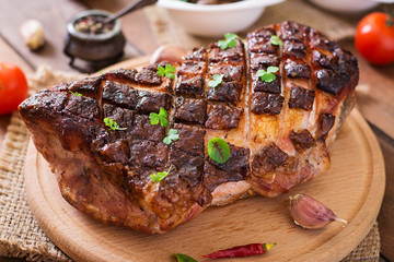 Baked meat with spices and garlic on wooden table