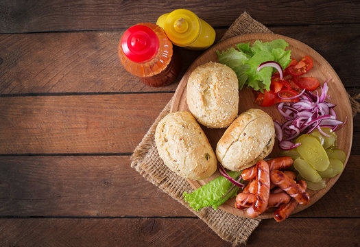 Ingredients for making Hot dog - sandwich with pickles, red onions and lettuce on wooden background. Top view