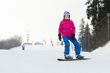 Woman snowboarder on the slopes frosty winter day. Beautiful girl on snoborde in the snow.