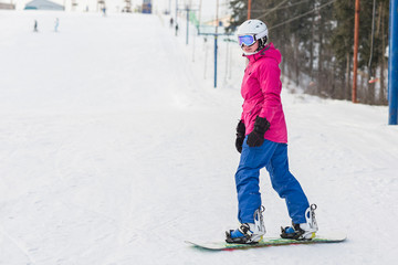 Woman snowboarder on the slopes frosty winter day. Beautiful girl on snoborde in the snow.