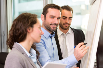 Obraz premium Young attractive businessman working at the office with associat