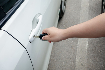 woman hand holding car keys to unlock or lock the white car