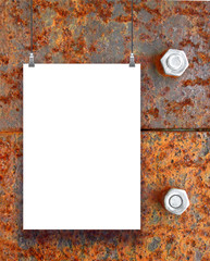 Close-up of one hanged paper sheet with clips on brown rusty metal background