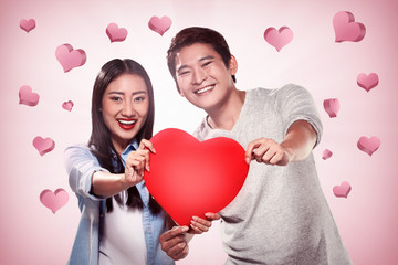 Portrait of man and woman holding red heart