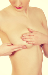 Woman examining breast.