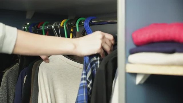 Clothing hanging on hangers at clothes cupboard