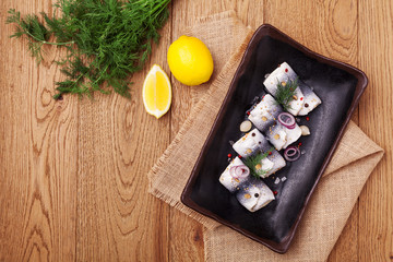 Rolled herring in vinegar, served with onions and pickles.