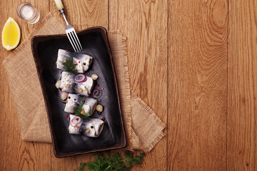 Rolled herring in vinegar, served with onions and pickles.