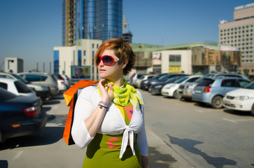 Young beautiful woman with bags after shopping in the parking