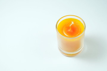 orange candles aroma in clear glass on white background