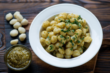 Glass plate of gnocchi with pesto sauce, selective focus