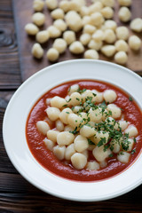 Close-up of gnocchi with tomato sauce and fresh parsley