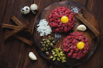 Above view of beef tartare on a dark rustic wooden background