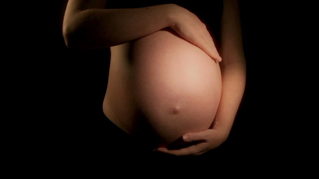 Pregnant woman strokes tummy (HD)