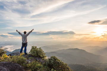 Tourist man spread hand on top of a mountain enjoying valley view - Powered by Adobe