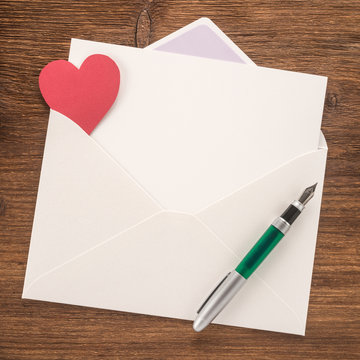 White envelope with heart and a pen


