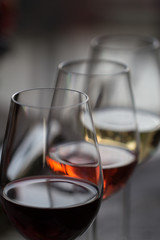 three wineglasses with red, rose and white wine 