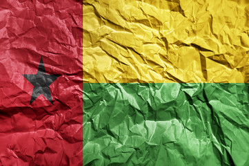 Guinea Bissau flag painted on crumpled paper background