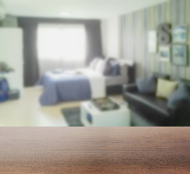 wooden table top with blur of blurred background bedroom with sofa