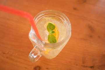 mint in a glass of ice orange juice, selective focus , top view