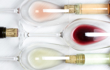 three bottles of Red ,white and rose wine and glasses isolated on wood textured white background 