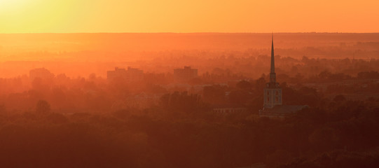 view of the city with a church at sunset
