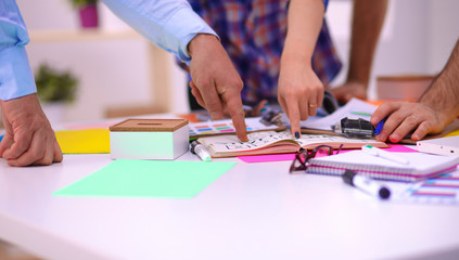 Obraz premium Close-up of three young creative designers working on project together. Team work