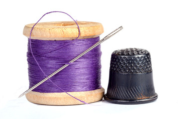 Old thimble and needle with thread