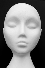 Close-up of white mannequin isolated on black