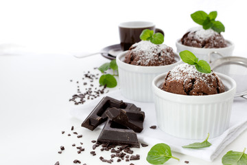 Chocolate muffins in white ramekins with leaves of mint