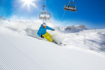 Skier skiing downhill in high mountains