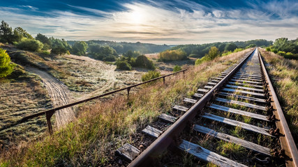 Fototapeta premium Old railway line in the frosty morning over the forest