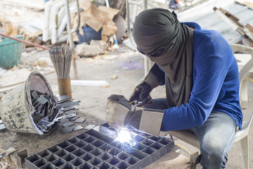 Worker welding steel in construction site.

