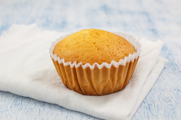 Homemade Vanilla cupcake on blue wooden background